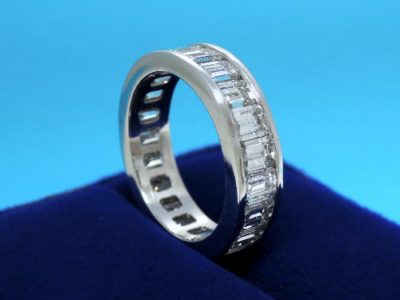Diamond eternity band with twenty-one emerald cut diamonds with 5.31 total carat weight channel-set in a platinum band 