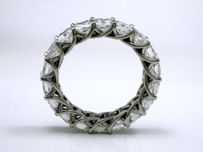 Eternity band with 18 shared-prong set square radiant cut diamonds (4.84 total carat weight) in trellis-style shank