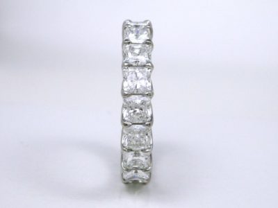 Eternity band with 18 shared-prong set square radiant cut diamonds (4.84 total carat weight) in trellis-style shank