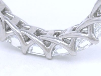 Trellis-style band with shared-prong set square radiant diamonds