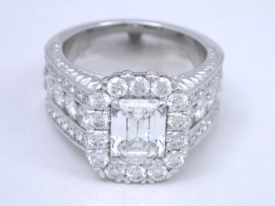 Diamond  ring with 1.20-carat emerald cut diamond prong-set in an 18-karat white-gold mounting with 8 shared-prong set on the shank and 38 pave-set diamonds in flanking rows on the shank and 3 on each side of the shank under the head