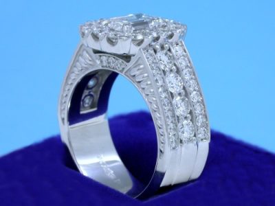 Diamond  ring with 1.20-carat emerald cut diamond prong-set in an 18-karat white-gold mounting with 8 shared-prong set on the shank and 38 pave-set diamonds in flanking rows on the shank and 3 on each side of the shank under the head