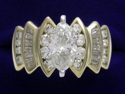 1.29 carat Marquise Cut diamond ring with 1.00 tcw of round and baguette diamonds in a yellow gold mounting. 