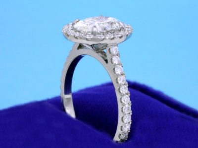 Oval cut diamond ring with pave diamond halo and shank