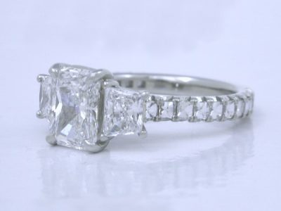 Three stone diamond engagement ring with radiant cut, brilliant cut trapezoid and Blaze Cut diamonds