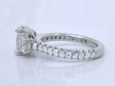 Radiant cut diamond ring with brilliant cut trapezoids side diamonds in modified baskets that accommodate a flush fitting wedding band