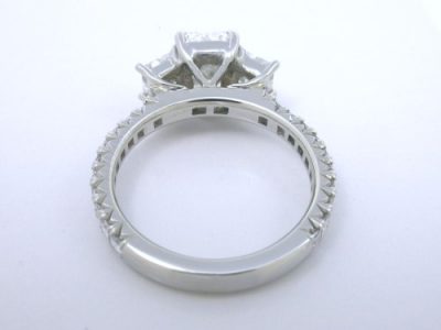 Three stone diamond ring with 1.13 carat radiant cut center diamond and 0.60 total carat weight side diamonds