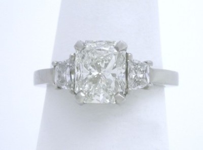 Three stone diamond ring with 1.51 carat cut-cornered rectangular modified brilliant (radiant) cut diamond set in a custom platinum basket-style mounting with matched pair of brilliant trapezoid cut diamonds 