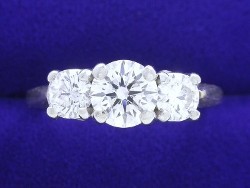 0.74 carat Round Brilliant Cut diamond in 3 Stone mounting with 0.60 total carat weight side Round Diamonds