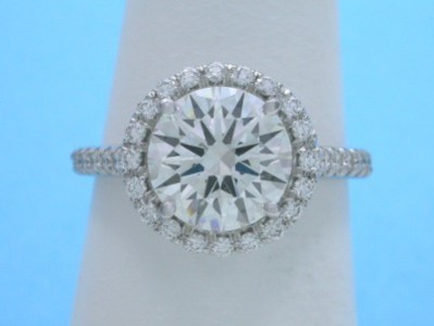 Round brilliant cut diamond engagement ring with pave halo and on the shank